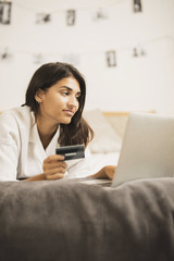 Indian woman working on a laptop and holding a card