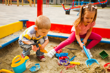 Adorable little kids playing in a sandbox