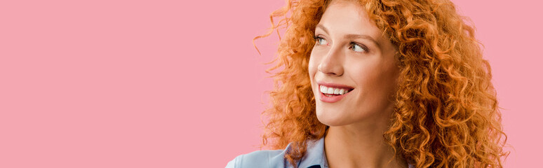 attractive redhead cheerful girl isolated on pink