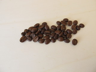 Roasted organic Arabian coffee beans on a wooden board