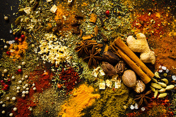 Top view of spices and herbs scattered on the board