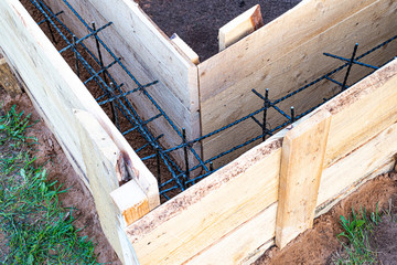 Wooden formwork with carbon fiber reinforcement inside, ready for concreting the Foundation of the village buildings.