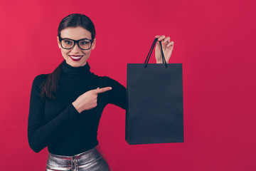 Portrait of her she nice-looking attractive pretty charming cheerful cheery glad girl showing black bag with new cool things isolated over maroon burgundy marsala red pastel color background