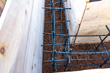 Wooden formwork with carbon fiber reinforcement inside, ready for concreting the Foundation of the village buildings.