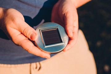Solar Energy Concept Image. Alternative energy source, mans hand holds portable solar charger