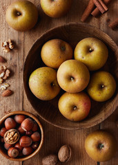 Autumn apples with nuts and cinnamon sticks on table