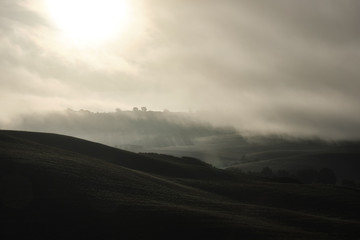 autumn on hill hills of tuscany italy during a foggy day morning