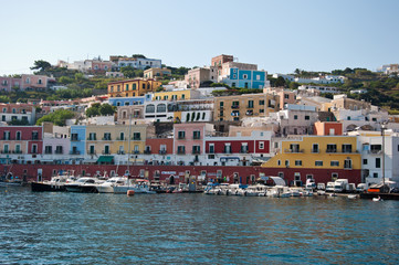 Fototapeta na wymiar Ponza, Lazio / Italy - August 9 2019: port of the island of Ponza in the summer. The typical colored houses of the island of Ponza. Landscape of the harbor of island of Ponza.