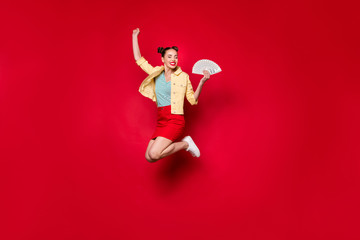 Jumping high overjoyed lady holding fan of bucks hands wear casual outfit isolated red background