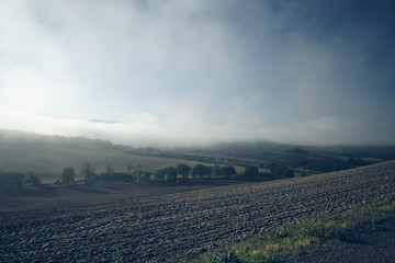 autumn on hill hills of tuscany italy during a foggy day morning