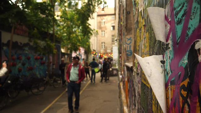 Street art alley in Berlin with tourists, Germany.