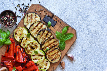 Grilled vegetables on a wooden board on the table. View from above.