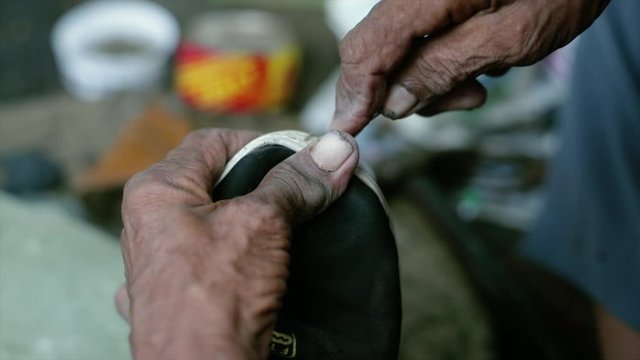 A cobbler repairing slippers of pilgrims by the roadside in the morning stock footage collection 22