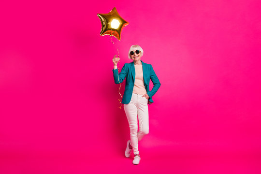 Full length body size view of nice-looking attractive well-dressed cheerful gray-haired lady holding balloon enjoying free time isolated on bright vivid shine vibrant pink fuchsia color background