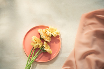 Flowers on the plate with fabric on yellow background