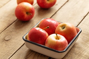 Red apple in plate on wooden background