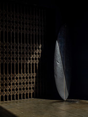 Lost surfboard near a vintage lift metallic door