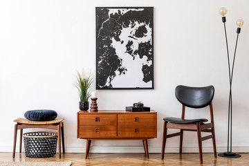 Stylish and retro living room with design vintage wooden commode, chair, footrest, black lamp and elegant personal accessories. Mock up poster map on the wall. Template. Vintage home decor. 