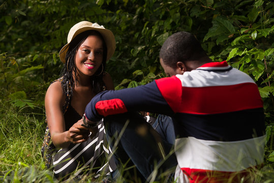 young couple sitting in the grass.
