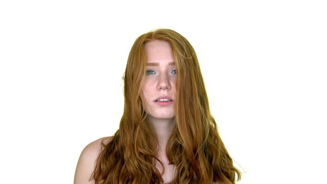 Beautiful sensual redhead woman with long wavy red hair looking at camera.