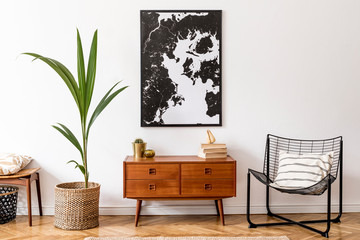 Stylish interior design of living room with wooden retro commode, chair, tropical plant in rattan...