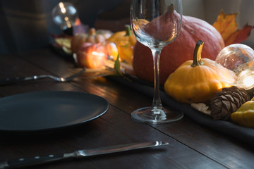 Autumn place setting with leaves, candles and pumpkins
