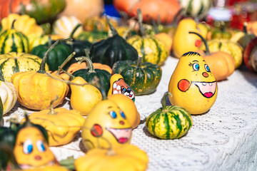 Smiley faces painted on pumpkins on autumn fair