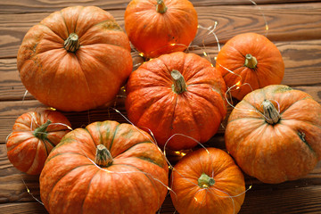 pumpkins with a shining garland on a wooden table