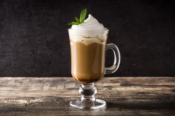 Peppermint coffee mocha for Christmas on wooden table and black background. 
