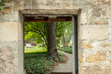 Steinerner Eingang mit Weg und Bäumen zu einem Park  Fokus Vordergrund
