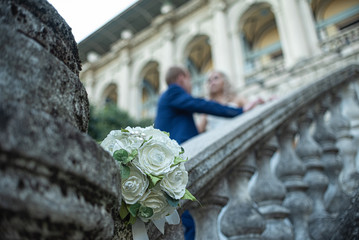 wedding bouquet of green and white flowers on the stone staircase
