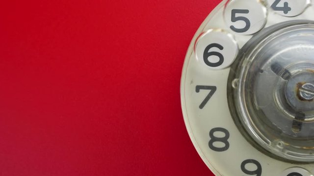 Dialing on an old rotary style telephone. Close-up view.