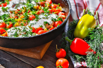 fried eggs with vegetables in a pan