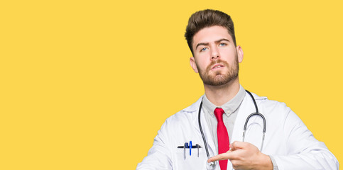 Young handsome doctor man wearing medical coat In hurry pointing to watch time, impatience, upset and angry for deadline delay