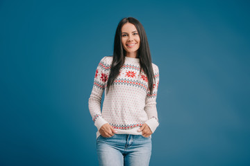cheerful woman posing in winter sweater isolated on blue
