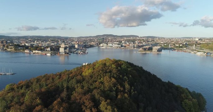 Cinema 4K drone shot with forward tilt reveal motion of Hoved&oslash;ya island, the blue Oslofjord and the Bj&oslash;rvika project with the Lambda Edvard Munch Museum and Opera House in autumn fall, in Oslo Norway.