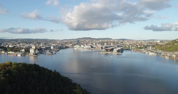 Cinema 4K drone shot with forward tilt reveal motion of Hoved&oslash;ya island, the blue Oslofjord and the Bj&oslash;rvika project with the Lambda Edvard Munch Museum and Opera House in autumn fall, in Oslo Norway.