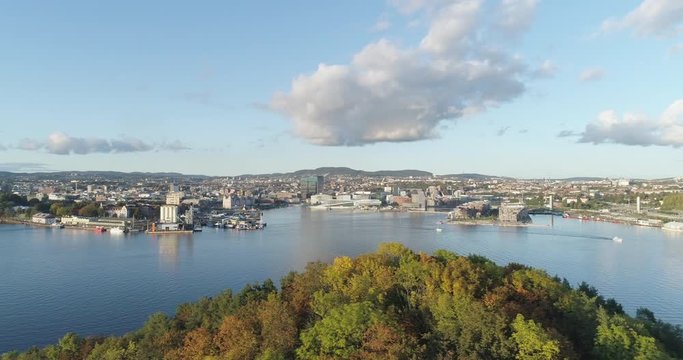 Cinema 4K drone shot with slide motion of Hoved&oslash;ya island, the blue Oslofjord and the new Bj&oslash;rvika quarter project with the Lambda Munch Museum and Oslo Opera House in autumn fall, in Oslo Norway.