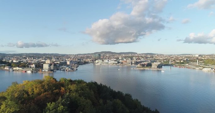 Cinema 4K drone shot with slide motion of Hoved&oslash;ya island, the blue Oslofjord and the new Bj&oslash;rvika quarter project with the Lambda Munch Museum and Oslo Opera House in autumn fall, in Oslo Norway.