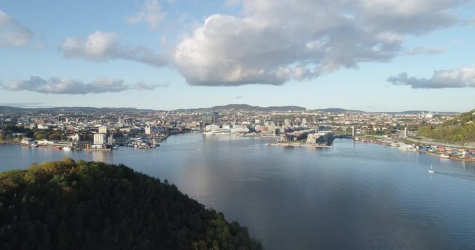 Cinema 4K drone shot with backward reveal motion of Hoved&oslash;ya island, the Oslofjord and the Bj&oslash;rvika project with the Lambda Edvard Munch Museum and Oslo Opera House in autumn fall, in Oslo Norway.
