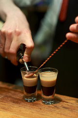 Barman make alcoholic shots with rum and liquor