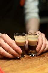 Barman make alcoholic shots with rum and liquor