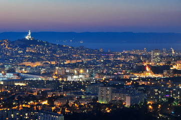 Fototapeta na wymiar Marseille city center and Notre Dame de la Garde at blue hour from the hills