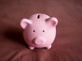 pink piggy bank on dark red background, Saving money for future plan and retirement fund concept