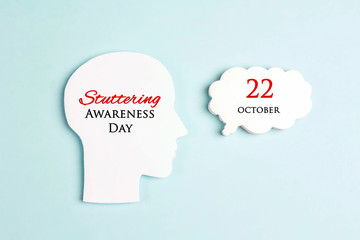 International Stuttering Awareness day, 22 October. Face profile silhouette with speech bubble on a blue background.