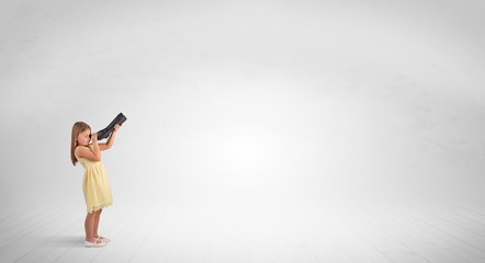 Cute little girl looking through spyglass to an empty space