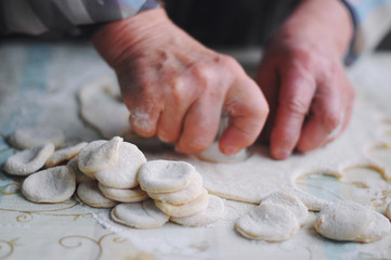 Woman molds Ukrainian dumplings.Ukrainian traditional dish