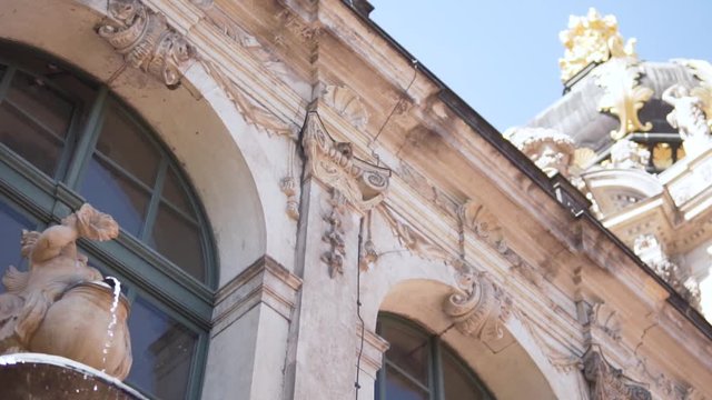 Close-up part of an ancient building with a fountain on a wall. 