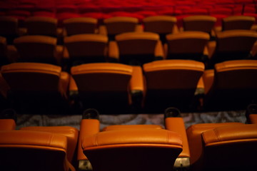 Fototapeta premium brown special leather seat in movie theater. pattern of many armchairs in dark room .