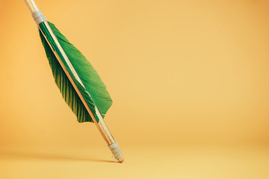 Old green wooden arrow on a beautiful YELLOW background.